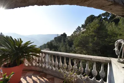 a patio with a table and chairs on a balcony at Studio climatisé et sa terrasse privée en villa in La Trinité