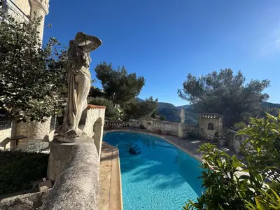 a bedroom with a white bed in a room at Studio climatisé et sa terrasse privée en villa in La Trinité