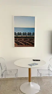 a table and chairs in a room with a picture on the wall at Studio Carré d'Or in Nice