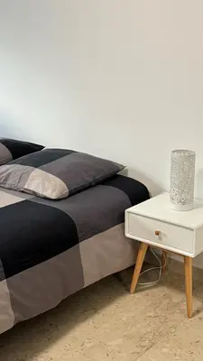 a bed with a white nightstand next to a bed with a bed sidx sidx at Studio Carré d'Or in Nice