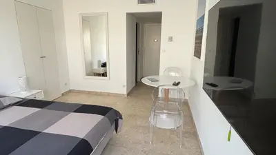 a bedroom with a bed and a table and chairs at Studio Carré d'Or in Nice