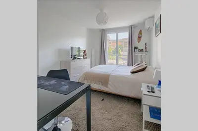 a bedroom with a bed and a desk and a window at Charme et Confort pour vos vacances sur Nice in Nice