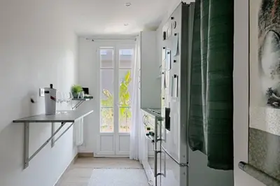 a kitchen with white walls and a door with a window at Charme et Confort pour vos vacances sur Nice in Nice