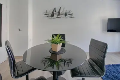 a dining room with a glass table and chairs at Charme et Confort pour vos vacances sur Nice in Nice