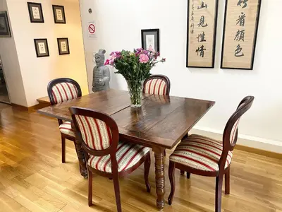 a wooden table with chairs and a vase of flowers on it at Samourai Massena Lodge -1 min from the sea in Nice