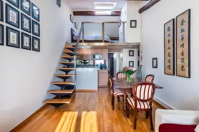 a kitchen and dining room with a spiral staircase and a table and chairs at Samourai Massena Lodge -1 min from the sea in Nice