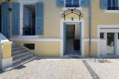 a building with blue shuttered windows and a door at Villa Capriciosa - Five Stars Holiday House in Beaulieu-sur-Mer