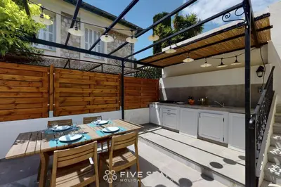 an outdoor kitchen with a table and chairs on a patio at Villa Capriciosa - Five Stars Holiday House in Beaulieu-sur-Mer