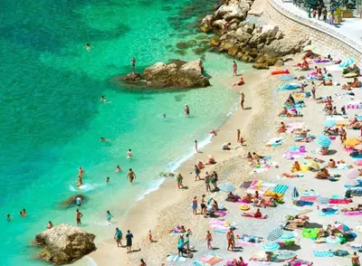 a group of people on a beach in the water at La NONETE in Villefranche-sur-Mer