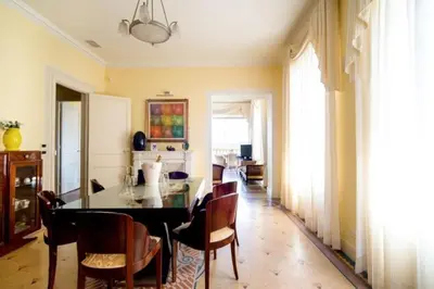 a dining room with a glass table and chairs at La NONETE in Villefranche-sur-Mer
