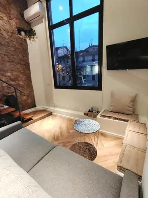 a living room with a couch and a large window at 35m2, luminous loft close to the beach in Villefranche-sur-Mer