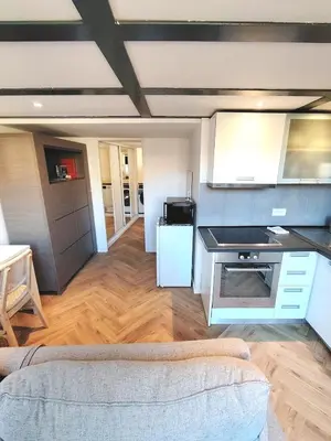 a living room with a couch and a kitchen at 35m2, luminous loft close to the beach in Villefranche-sur-Mer