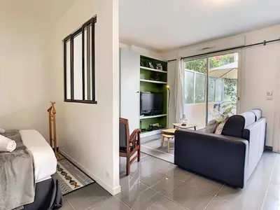 a living room with a couch and a tv at Nestor&Jeeves - BERLIOZ PATIO - Central - Residential area - Patio 20m in Nice