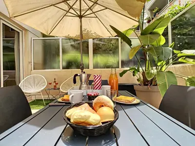 a table with a basket of bread and an umbrella at Nestor&Jeeves - BERLIOZ PATIO - Central - Residential area - Patio 20m in Nice