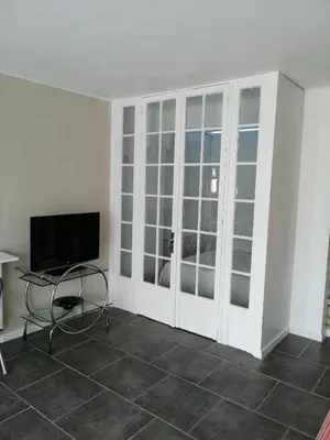a room with a tv and a table and a chair at Loft 1 in La Trinité