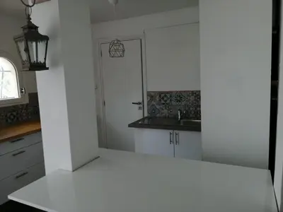 a kitchen with a white counter and a sink at Loft 1 in La Trinité