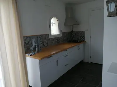 a kitchen with white cabinets and a window at Loft 1 in La Trinité