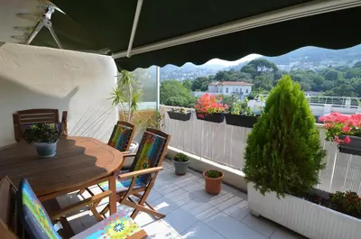 a patio with a table and chairs on a balcony at PHOENIX - Appartement 4 personnes avec superbe terrasse, clim et parking le port de Nice in Nice