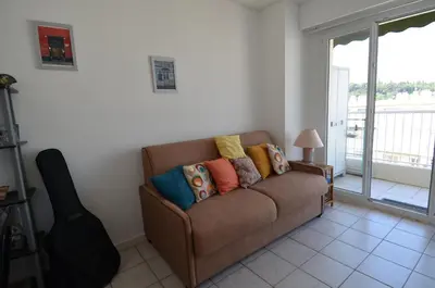a brown couch in a living room with a window at PHOENIX - Appartement 4 personnes avec superbe terrasse, clim et parking le port de Nice in Nice