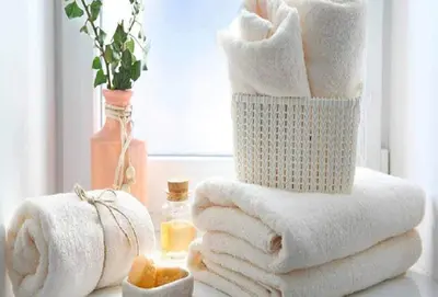 a stack of towels on a table with a window at ApartHotel Riviera - JEAN JAURES 1 - Vieille Ville - Appartement de 3 pieces AC - 100m de la plage in Nice