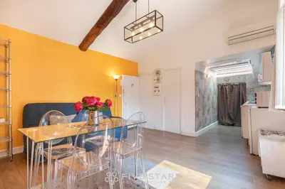 a dining room and living room with a glass table at Vieux Nice - Jean Jaurès FSHH in Nice