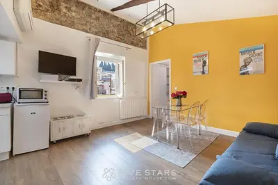 a living room with a blue couch and yellow walls at Vieux Nice - Jean Jaurès FSHH in Nice