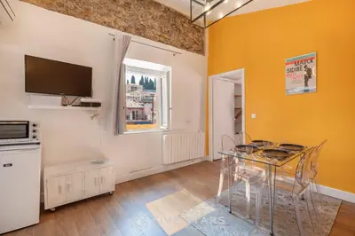 a dining room with a table and a tv at Vieux Nice - Jean Jaurès FSHH in Nice