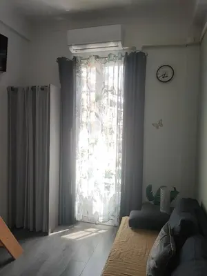a bedroom with a window with curtains and a couch at Superbe studio sur Nice in Nice