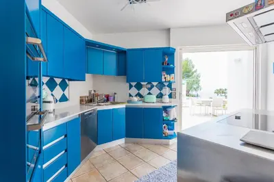a blue kitchen with white counters and blue cabinets at VILLA NICE-GAIRAUT by RIVIERA HOLIDAY HOMES in Nice