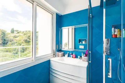 a blue bathroom with a sink and a window at VILLA NICE-GAIRAUT by RIVIERA HOLIDAY HOMES in Nice