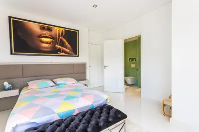 a bedroom with a bed and a painting on the wall at VILLA NICE-GAIRAUT by RIVIERA HOLIDAY HOMES in Nice