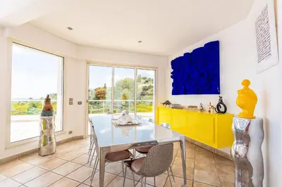 a dining room with a table and a yellow cabinet at VILLA NICE-GAIRAUT by RIVIERA HOLIDAY HOMES in Nice