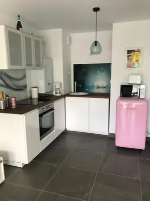 a kitchen with white cabinets and a pink refrigerator at Appartement à Nice in Nice