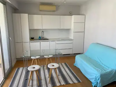 a small kitchen with a couch and a table in a room at Studio vue mer in Beaulieu-sur-Mer