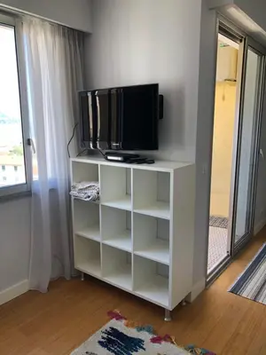 a tv on a white stand with a tv at Studio vue mer in Beaulieu-sur-Mer