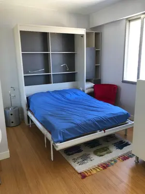 a bedroom with a bed with a blue blanket at Studio vue mer in Beaulieu-sur-Mer