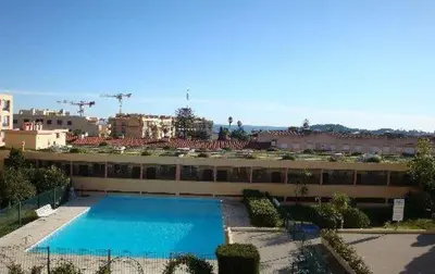 a large building with a large swimming pool at Studio vue mer in Beaulieu-sur-Mer