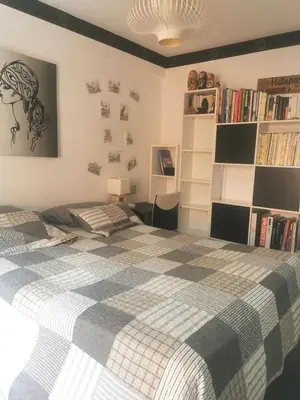 a bedroom with a bed and a book shelf at CHAMBRE CHEZ L'HABITANT - ROOM IN THE OWNER'S APARTMENT in Nice