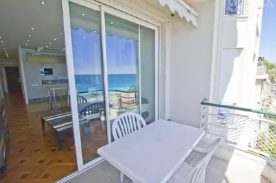 a white table and chairs on a balcony with a view of the ocean at Florida Sea Front in Nice