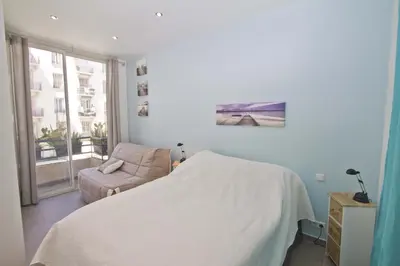 a bedroom with a bed and a chair and a window at Florida Sea Front in Nice