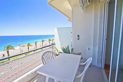 a white table and chairs on a balcony with the beach at Florida Sea Front in Nice