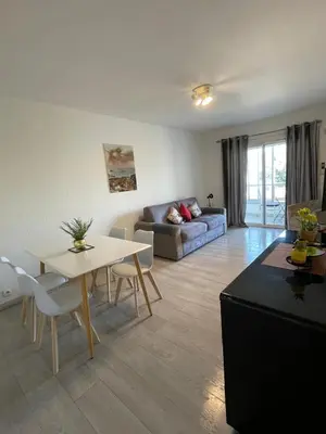a living room with a white couch and blue chairs at Beau Studio à 50m de la plage in Nice