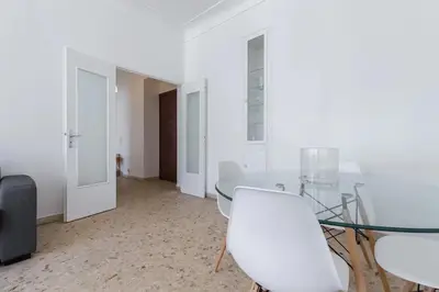 a dining room with a glass table and white chairs at FEEL HOME - ASSALIT in Nice