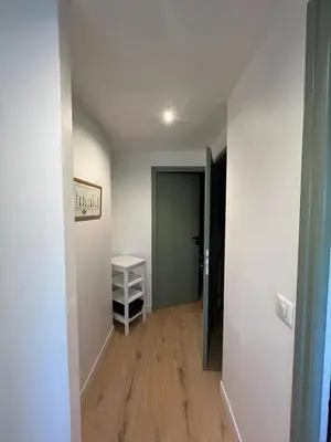 an empty room with a hallway with a door and a table at 3 Piéces confort climatisé vue mer, 4 personnes à Saint-Jean Cap Ferrat à proximité de monaco et menton in Saint-Jean-Cap-Ferrat