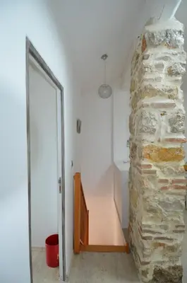 a room with a stone wall next to a doorway at DUPLEX BORRIGLIONE - Spacieux appartement pour 6 personnes au pied du tram in Nice