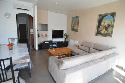 a living room with a couch and a table at DUPLEX BORRIGLIONE - Spacieux appartement pour 6 personnes au pied du tram in Nice