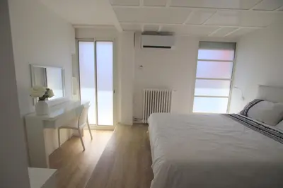 a white bedroom with a desk and a bed at La terrasse de Carras in Nice
