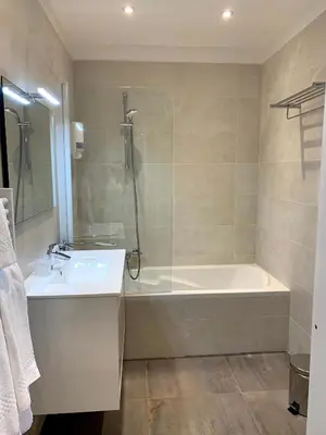 a bathroom with a bath tub and a sink at Share Inn Appartements in Nice
