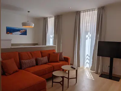 a living room with an orange couch and a tv at Share Inn Appartements in Nice