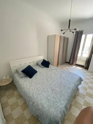 a bedroom with a bed with blue pillows on it at Maisonnette Cagnes in Cagnes-sur-Mer